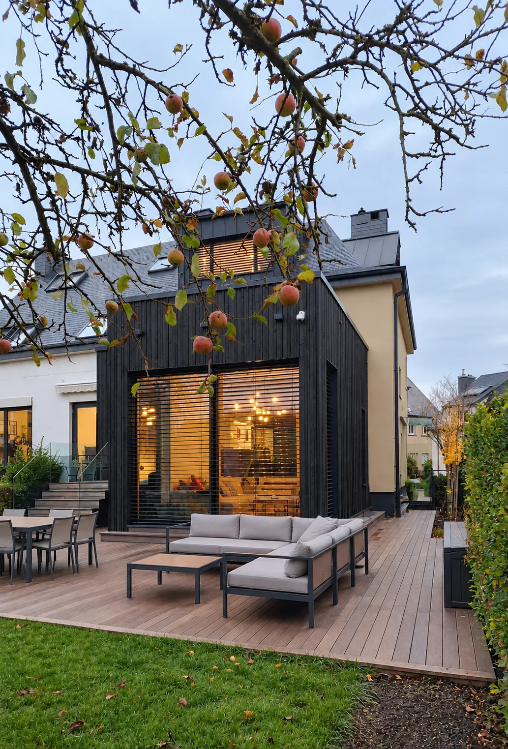 Extension de maison à Steinsel : volume en bois noirci ouvert sur une terrasse en bois